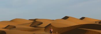 Motocycliste dans le désert près de Dakar, ciel bleu.