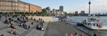 Vue panoramique Roanne, rivière calme, bateaux à quai, journée ensoleillée.