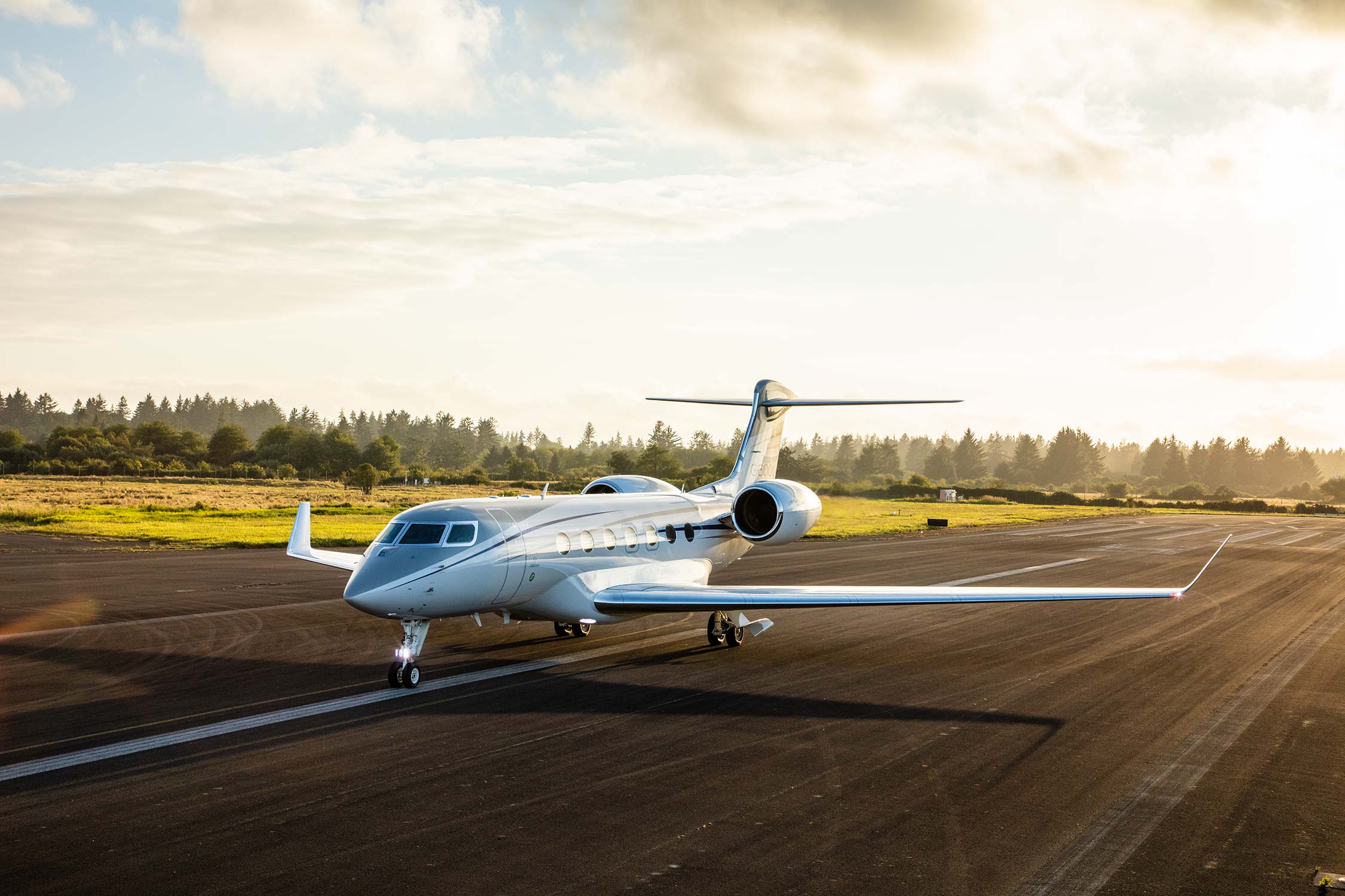 G550 jet privé en vol au dessus des nuages au couché de soleil